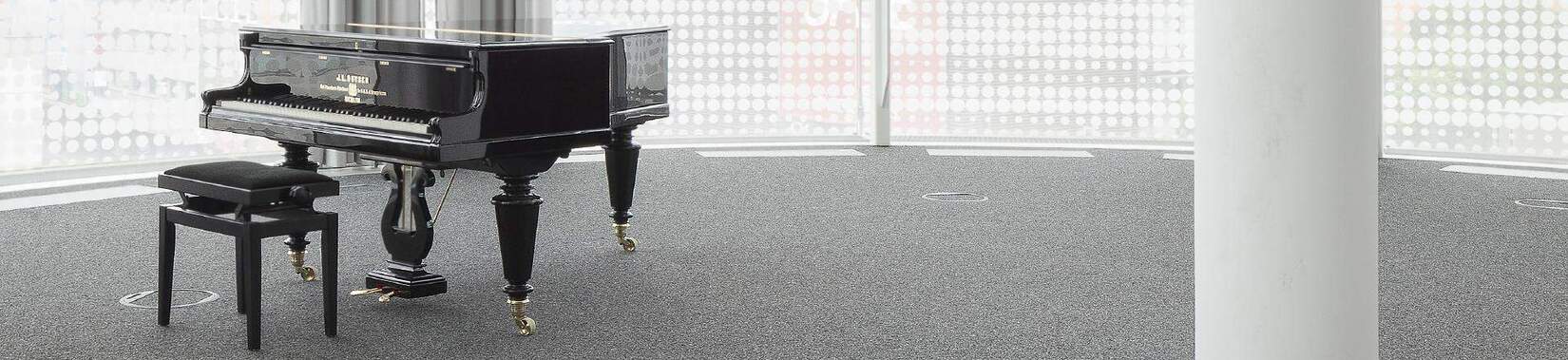 Ein schwarzes Piano in hellem, leeren Raum
