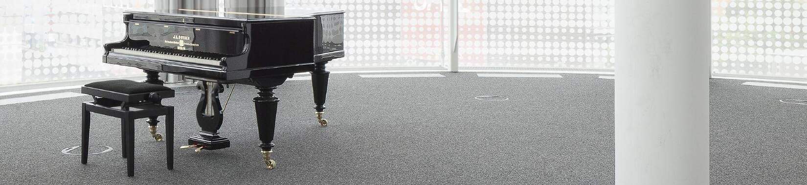 A black piano in a bright, empty room